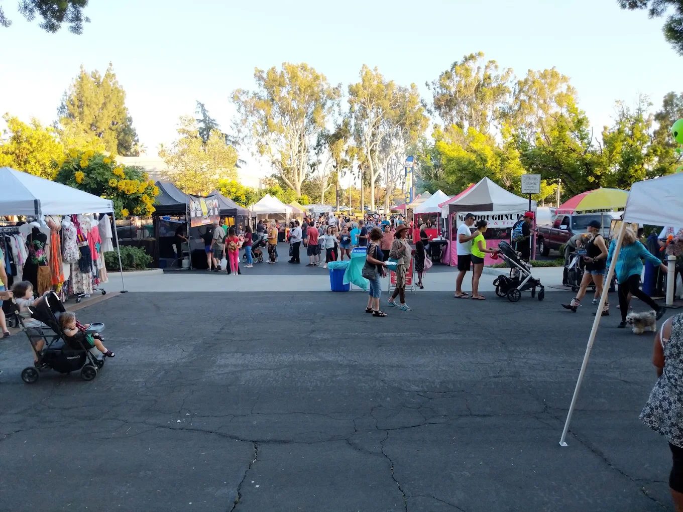 Clothing and craft tents filling the City Hall parking lot on a Wednesday evening
